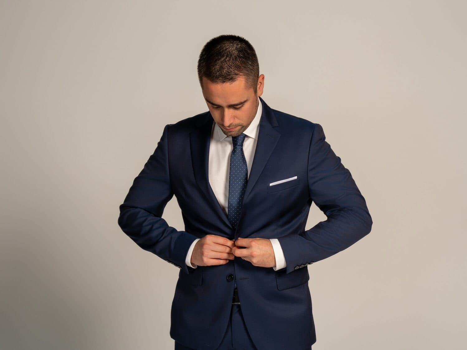 Chris Stambolidis, founder of Career Solutions Group — candid detail, buttoning the jacket